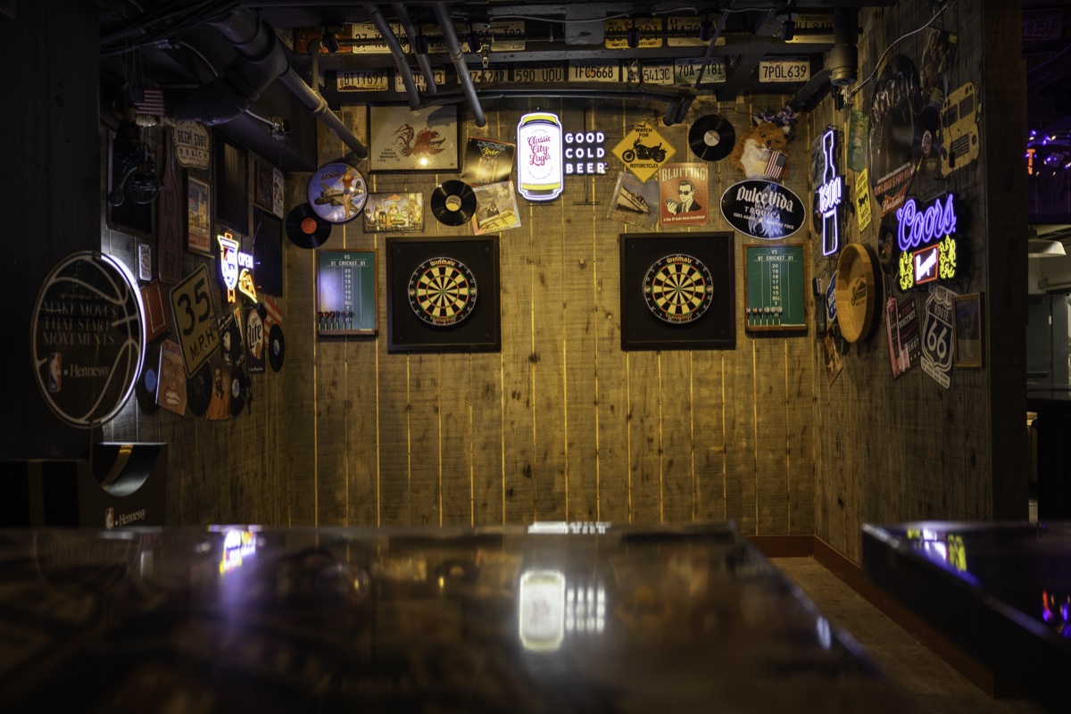 Two dartboards surrounded by vintage signs and records.