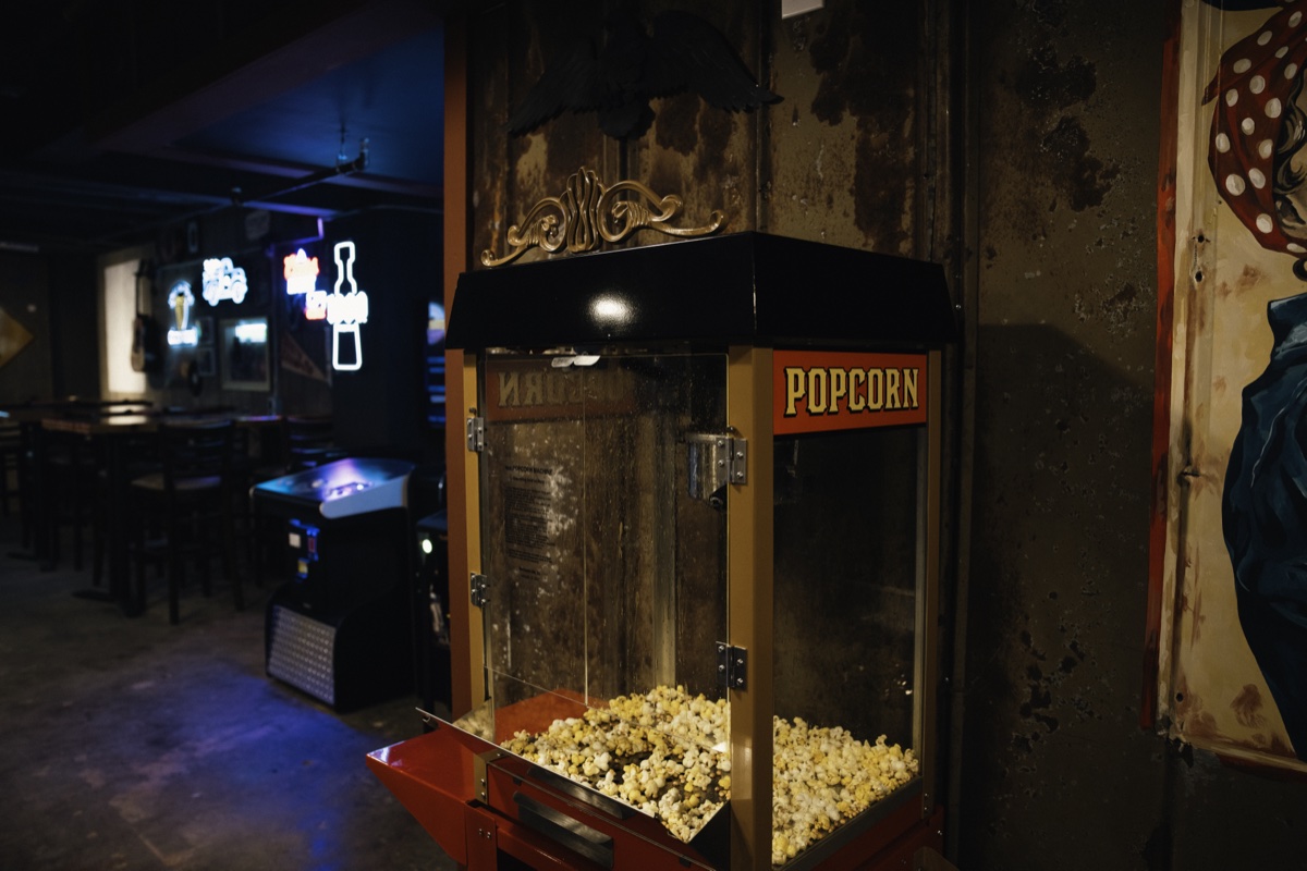 The popcorn machine with neon signs in the background.